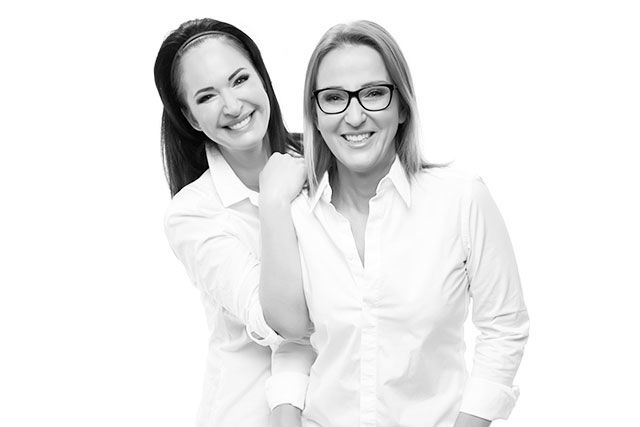dwie kobiety uśmiechnięte w białych koszulach trener makijażu permanentnego